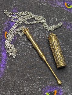 an antique brass baseball bat and chain on a tablecloth with purple flowers in the background