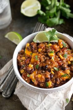 a white bowl filled with chili and corn on top of a napkin next to a fork