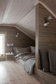 an attic bedroom with wooden walls and flooring