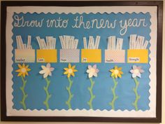 a bulletin board with flowers and words written in white writing on blue paper that says grow into the new year