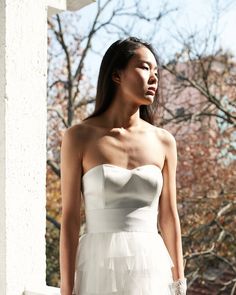 a woman in a white dress standing on a porch