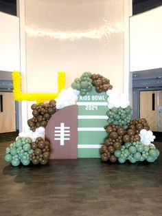 a football themed centerpiece in the middle of a hall with balloons and streamers