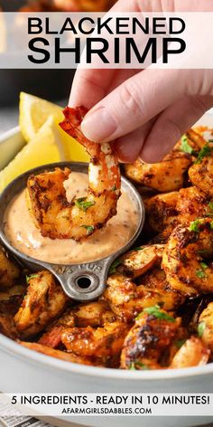 a person dipping sauce on shrimp in a bowl