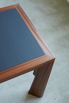 a close up of a wooden table with a black board on the top and bottom