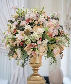 a gold vase filled with pink and white flowers