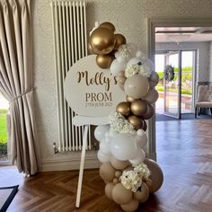 a balloon arch with balloons and flowers on it in front of a door that says melly's prom