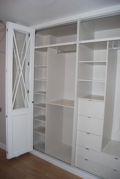 an empty closet with white shelves and drawers