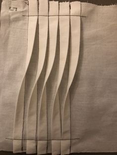 four pieces of white linen with black stitching on them, lined up in rows