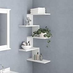 a bathroom with blue walls and white shelving on the wall next to a sink