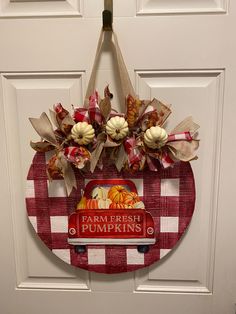 a red and white checkered door hanger that says farm fresh pumpkins on it