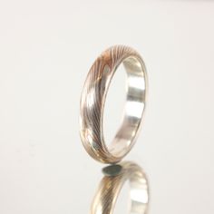 Our handcrafted Silver and Bronze Mokume Gane ring is a unique and timeless piece of jewelry. Using the ancient technique of Mokume Gane, this ring is crafted with layers of Sterling Silver and Bronze, creating a one-of-a-kind pattern. These rings are etched and lightly oxidised to bring out the colors of the metals and have a sterling silver liner that makes the ring hypoallergenic. These rings are made to order so please allow 3 to 4 weeks for delivery. These rings are made individually so each ring is unique and will vary slightly from what is pictured, Variations in color and patterning are natural features of Mokume Gane and photos shown are for illustration purposes only. PROFILE : Domed or Flat ORDER DETAILS If you don't see your size in the menu or your not sure of your size, write Silver Liner, Mokume Gane Ring, Mokume Gane, Enamel Ring, Ring Sizer, Enamel Earrings, Pendant Rings, Silver Pendant Necklace, Adjustable Rings