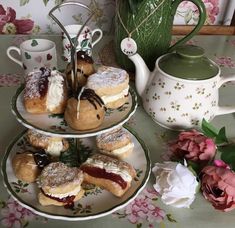 three plates with pastries on them sitting next to a tea pot and flower vase