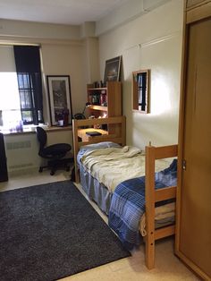 a bedroom with a bed, desk and bookcases in the corner next to a window