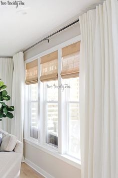 a living room with white curtains and a plant on the window sill in front of it