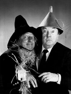 two men dressed in black and white posing for a photo with a party hat on their head