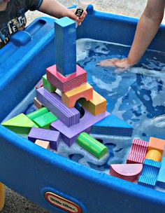 a child playing in a pool with blocks