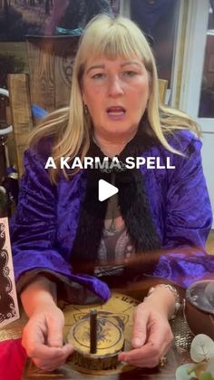 a woman sitting at a table with a clock in front of her and the words karma spell on it