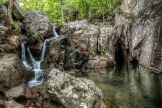 there is a waterfall in the middle of some rocks