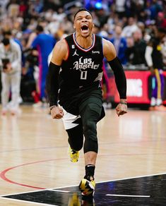 a basketball player is running on the court with his mouth open and tongue hanging out