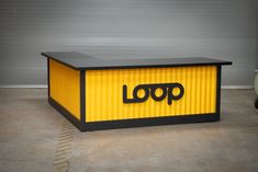 a yellow and black box with the word loop on it's side in front of a garage door