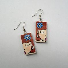 "Unique handmade earrings featuring a runette girl. These earrings are distinctive and fun to wear. You can pair them with any outfit, be it casual, everyday or special occasions.  The girl earrings are crafted using polymer clay and a technique called Nambi. They are cured to ensure optimum color and strength and then hand-sanded, colored, and glazed. The front side of each earring features a drawing made by hand in clay. The motif on each earring is unique, similar but not identical. The back of the earrings is made of dark-colored clay and textured. Dimension: about 3 × 1,5 cm/ 1.18 × 0.6 inches   Total length of earrings (including ear wires) is 5 cm/ 1.80 inches. The earrings are already made and ready for shipping. They will be delivered in a lovely box and bubble wrap envelope. \".. Artistic Hand Painted Earrings, Unique Hand Painted Earrings For Everyday, Handmade Cute Plug Earrings For Gift, Unique Hand Painted Earrings For Everyday Wear, Cute Handmade Plug Earrings For Gift, Unique Hand Painted Everyday Earrings, Hand Painted Dangle Jewelry, Artistic Flower Earrings For Gifts, Hand Painted Artsy Earrings For Everyday