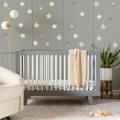 a baby's room with stars painted on the wall and a crib in the foreground