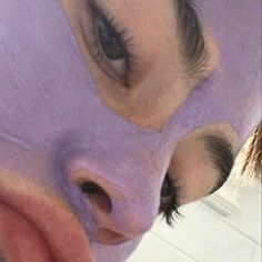 a close up of a person with a purple sheet on their face and one eye