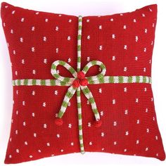 a red pillow with a green and white bow on it