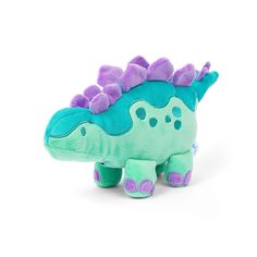 a stuffed toy dinosaur with purple and green spikes on it's head, sitting in front of a white background