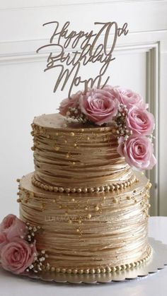 a three tiered cake with pink flowers on top and a happy birthday card in the middle