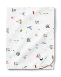 a white blanket with colorful cartoon animals and balloons on it, in front of a white background