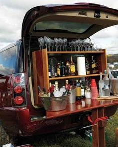 the back end of a van filled with bottles and glasses