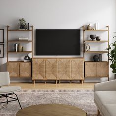 a living room with furniture and a flat screen tv mounted on the wall above it