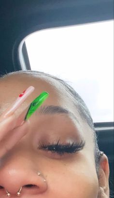 a woman with her eyes closed holding a green toothbrush