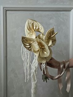 a bouquet of flowers with ribbons hanging from it's side, in front of a door