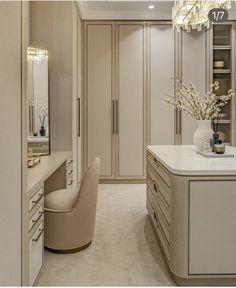 an elegant dressing room with white furniture and chandelier