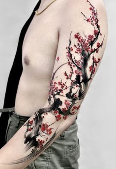 a man's arm covered in tattoos with red flowers and birds on the branches