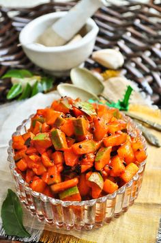 a glass bowl filled with chopped carrots on top of a table