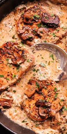 a skillet filled with chicken and mushrooms covered in gravy, garnished with parsley