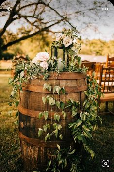 a wooden barrel with flowers and greenery on it