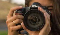 a woman is taking a photo with her nikon d700 digital slr camera