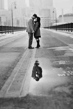 a man and woman are kissing on the street