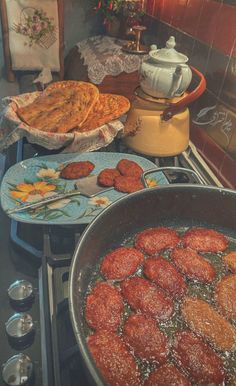 some food is cooking in a pan on top of the stove with other plates and utensils