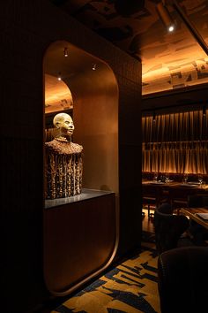 a fancy looking room with a gold mask on the wall and tables in the background