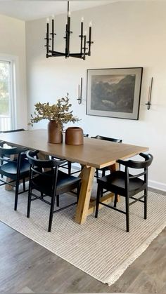 a dining room table with chairs and vases on it