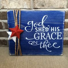 a wooden sign that says god shed his grace on the side with a red star