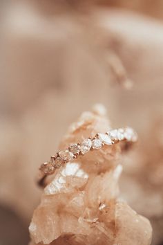 a diamond ring sitting on top of a piece of rock in front of a blurry background