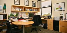 an office with two desks and several pictures on the wall