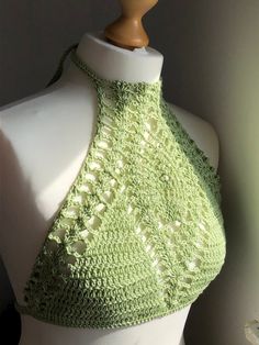 a green crocheted halter top on a mannequin