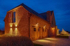 a brick building with lights on the side of it and a walkway leading up to it